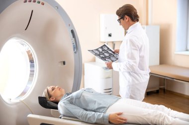 Bilgisayarlı tomografi testinin sonuçlarını analiz eden doktor