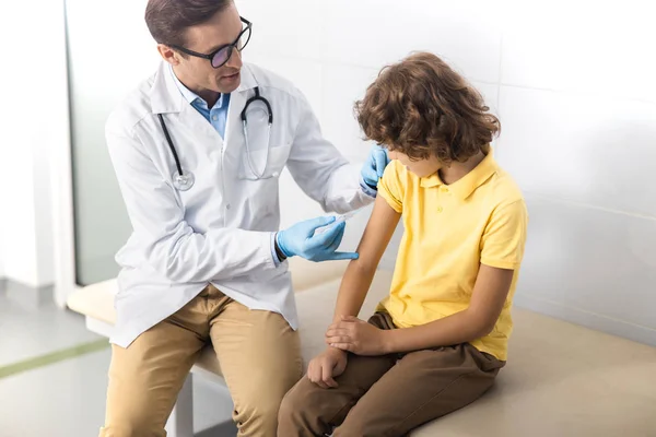 Kinderarts geven schot aan jongen in kliniek stockfoto — Stockfoto