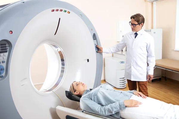 Young woman lying on CT scanner bed during tomography test in hospital — Stock Photo, Image