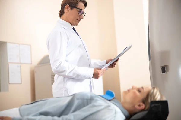 Médico analizando tomografía computarizada cerebral de mujer joven — Foto de Stock