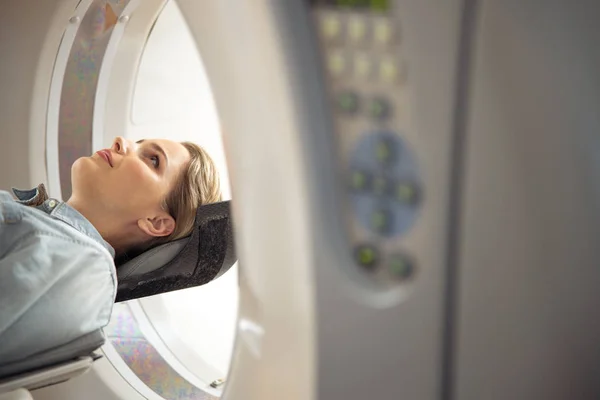 Wanita cantik berbaring di meja pemindai CT di klinik radiologi — Stok Foto