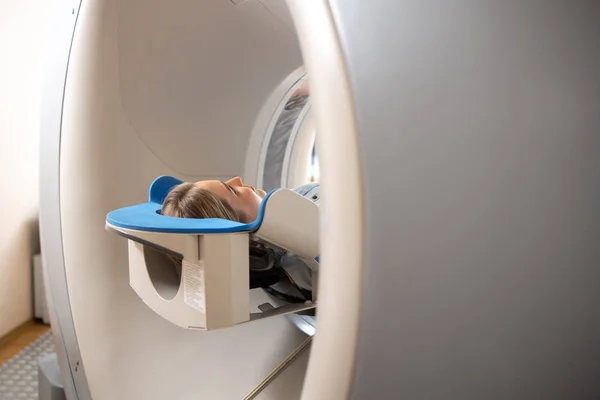 Молода жінка, лежачи на столі всередині CT машина — стокове фото