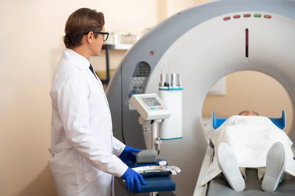 Доктор дивиться на леді під час процедури сканування CT — стокове фото