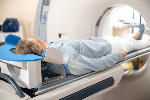 Young woman having computed tomography procedure at hospital