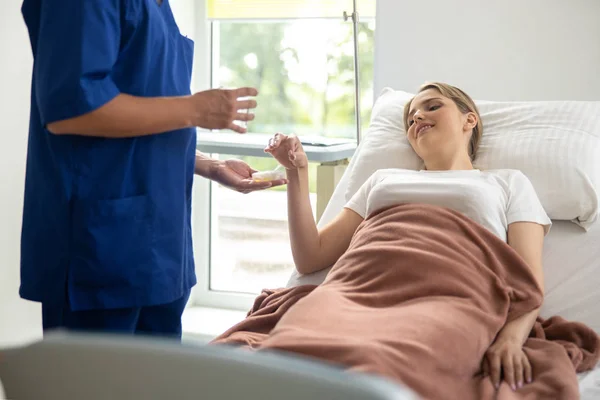 Médico dando pílulas para jovem mulher no quarto do hospital — Fotografia de Stock