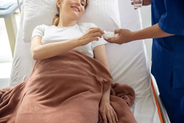 Médico dando pílulas para mulher jovem no quarto do hospital — Fotografia de Stock
