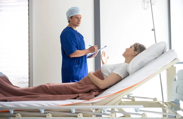 Jovem mulher dizendo médico sobre sua condição — Fotografia de Stock