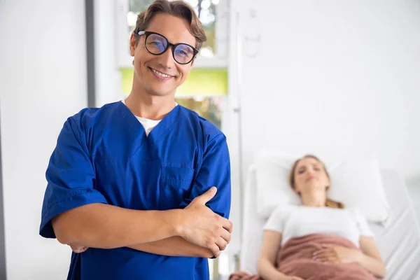 Guapo médico alegre con paciente sobre fondo borroso — Foto de Stock