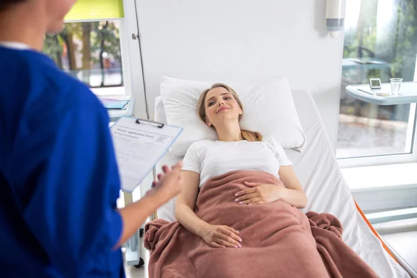Mooie dame praten met dokter in ziekenhuiskamer — Stockfoto