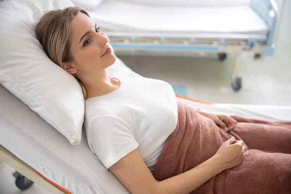 Attraktive Dame liegt in moderner Klinik im Bett — Stockfoto