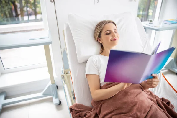 Schöne junge Frau liest im Krankenhauszimmer — Stockfoto