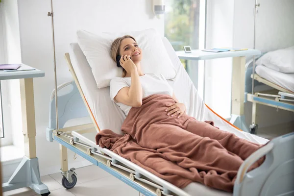 Schöne junge Frau telefoniert im Krankenhauszimmer — Stockfoto