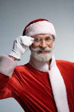 Yaşlı Noel Baba gülümseyerek ve kameraya bakıyor