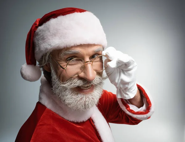 Пожилой Санта-Клаус улыбается и смотрит в камеру — стоковое фото