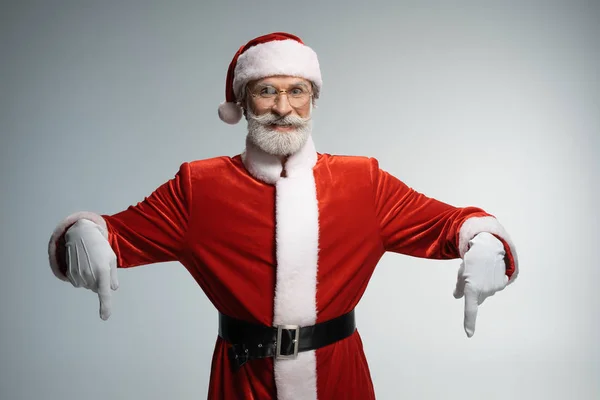 Зрелый Санта Клаус указывает пальцем вниз. — стоковое фото