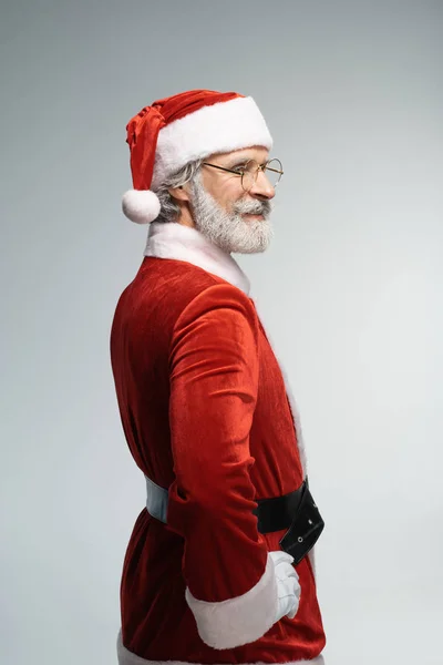 Санта-Клаус смотрит в сторону с широкой улыбкой — стоковое фото