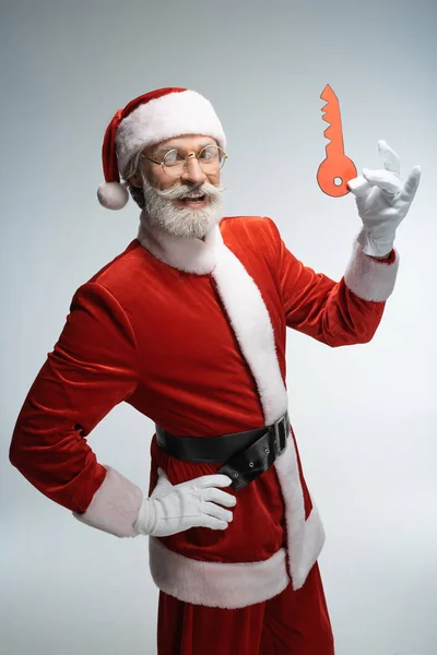 Santa Claus se usmíval v ruce s papírovým klíčem — Stock fotografie