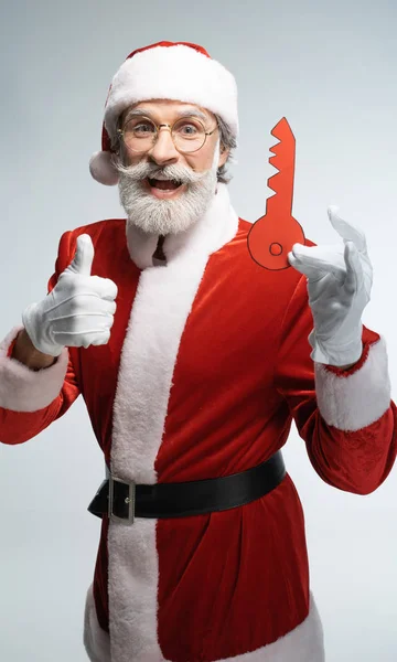 Santa Claus with paper key showing thumbs up — Stock Photo, Image