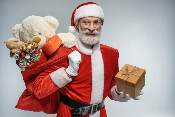 Père Noël tenant boîte cadeau et sac — Photo