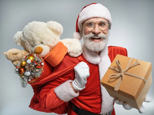 Santa Claus standing with sack and gift box — Stock Photo, Image