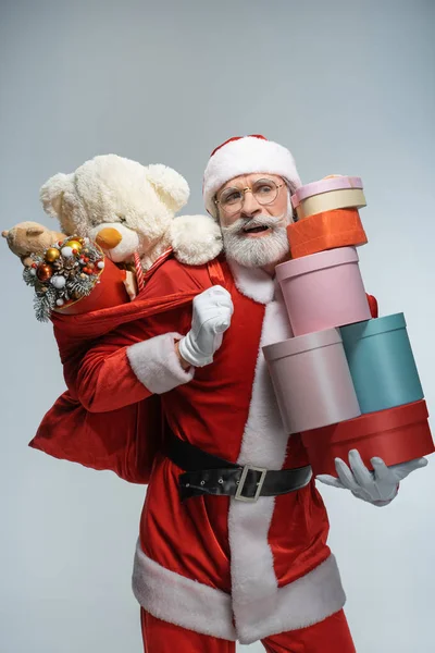 Dojrzały Święty Mikołaj trzyma worek i prezent pudełko — Zdjęcie stockowe