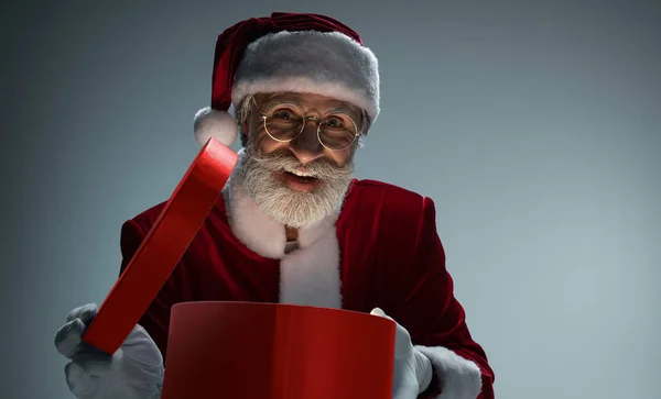 Święty Mikołaj z otwartym pudełku z upominkami w rękach — Zdjęcie stockowe