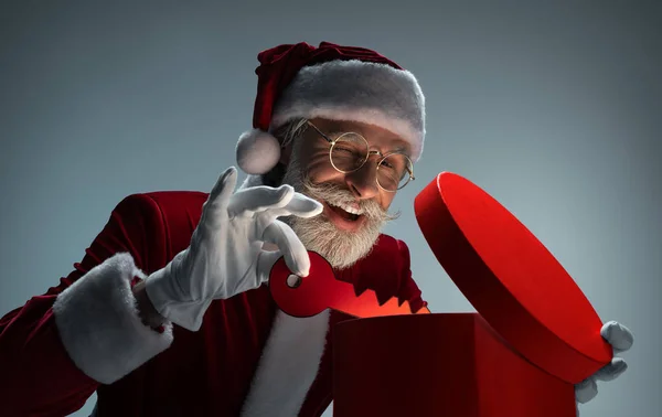 Elderly Santa Claus packing key in gift box — Stock Photo, Image