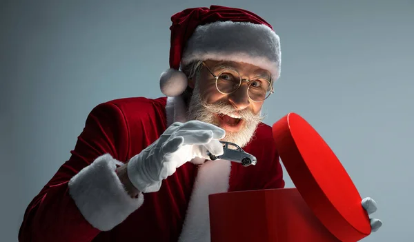 Santa Claus embalaje de coches en la caja de regalo abierta — Foto de Stock