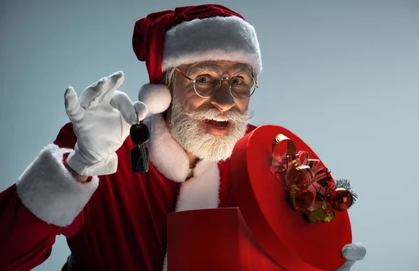 Mature Santa Claus holding gift box and car keys — Stock Photo, Image