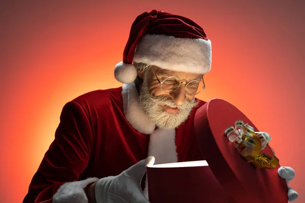 Ώριμος Άγιος Βασίλης κοιτάζοντας μέσα ανοιχτό κουτί δώρων — Φωτογραφία Αρχείου