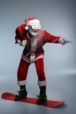 Olgun Noel Baba çuval tutan, snowboard ayakta