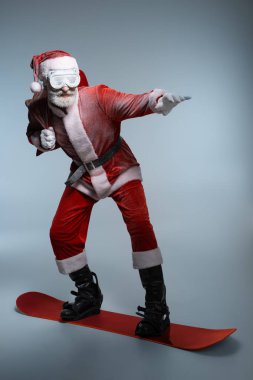 Yaşlı Noel Baba çuval tutan, snowboard ayakta