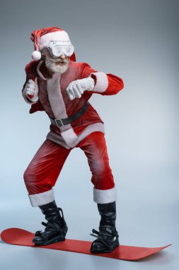 Kıdemli Noel Baba çuval tutan, snowboard ayakta