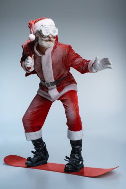 Olgun Noel Baba çuval tutan, snowboard ayakta