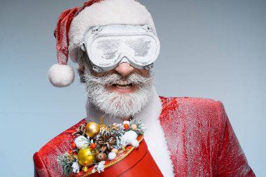 Kıdemli Noel Baba elinde yeni yıl hediyesi tutarak