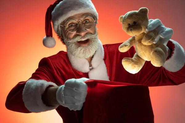 高齢サンタクロースは、プレゼントと袋の中におもちゃを梱包 — ストック写真