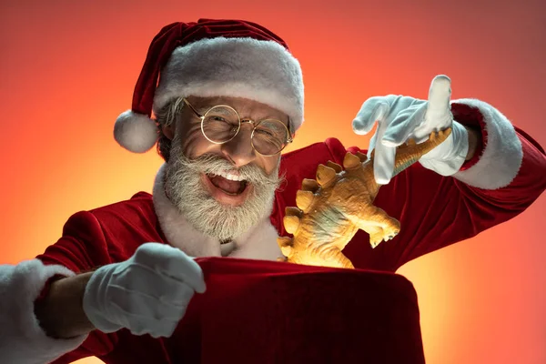 Mature aged Santa Claus packing toy inside sack — Stock Photo, Image