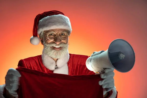 Père Noël senior tenant mégaphone et sac dans les mains — Photo
