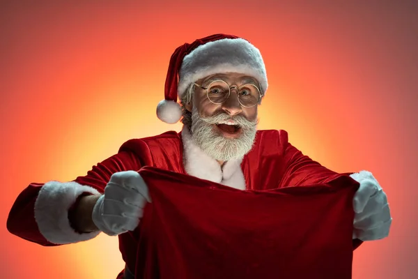 Święty Mikołaj trzyma worek z prezentami w rękach — Zdjęcie stockowe