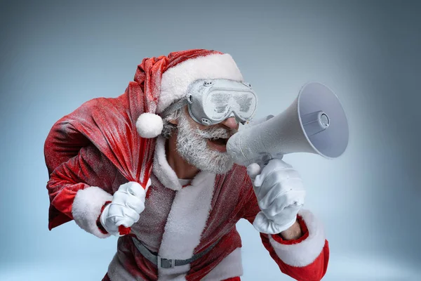 Mature Santa Claus with sack speaking at megaphone — Stock Photo, Image