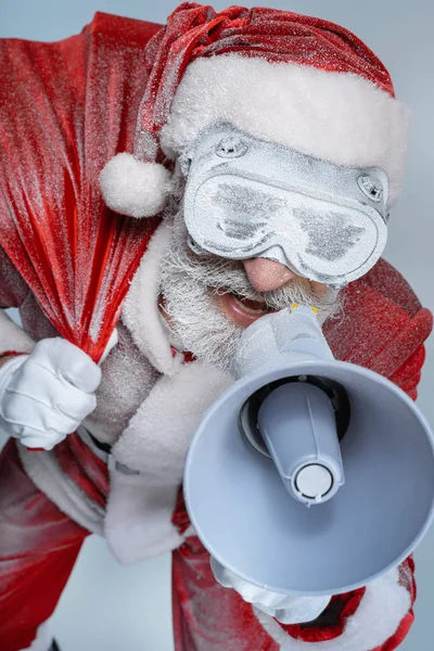 Mature aged Santa Claus with sack speaking at megaphone — Stock Photo, Image