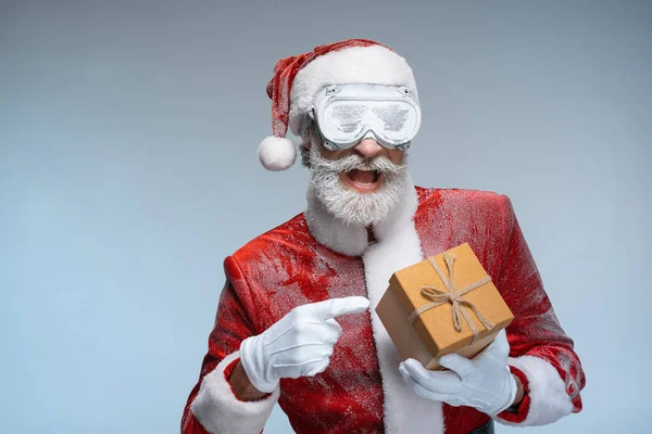 Santa Claus pointing at new year present in hand — Stock Photo, Image