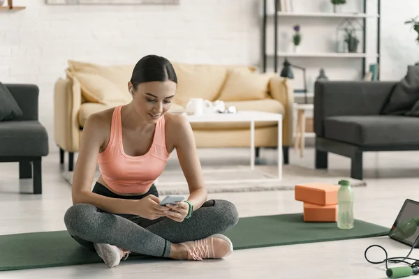 Mujer alegre ejercicio con gadget en casa stock foto —  Fotos de Stock