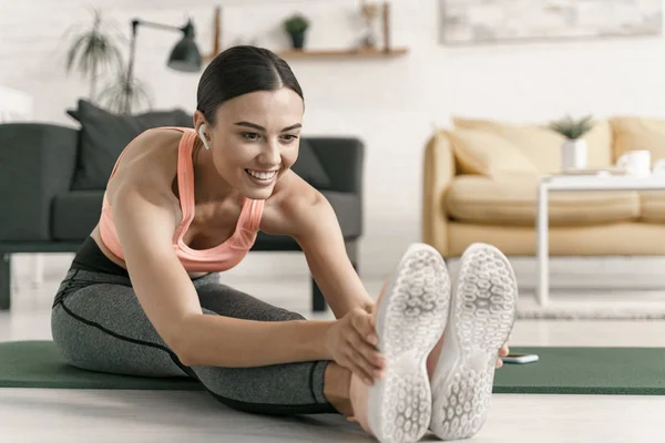 Mujer alegre estiramiento después del entrenamiento en casa foto de stock —  Fotos de Stock