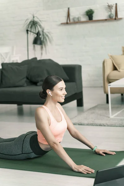 Mujer feliz ejercicio en casa cerca de la tableta foto de stock —  Fotos de Stock