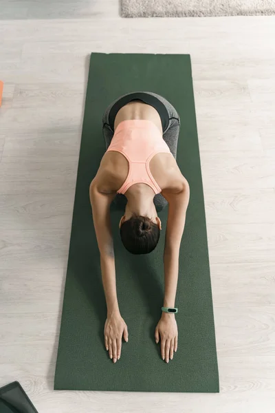 Sportliche Frau praktiziert Yoga drinnen Archivfoto — Stockfoto