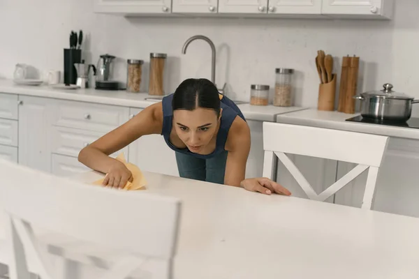 Young woman doing cleaning in kitchen stock photo