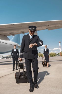 Yakışıklı Kafkas pilot havaalanında saat bakıyor