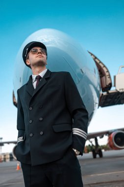 Havaalanında uçuş için bekleyen üniformalı sakin erkek pilot