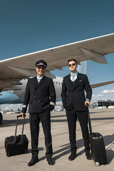 Gelukkig knappe piloten zijn klaar voor de vlucht in de luchthaven — Stockfoto